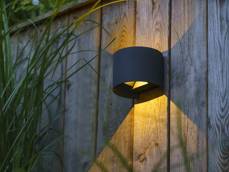 Wandleuchte Goura aus der Vogelperspektive an einem Holzzaun
