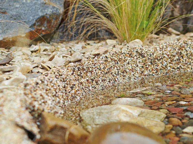 Nahaufnahme der Steinfolie Sand in einem Teich