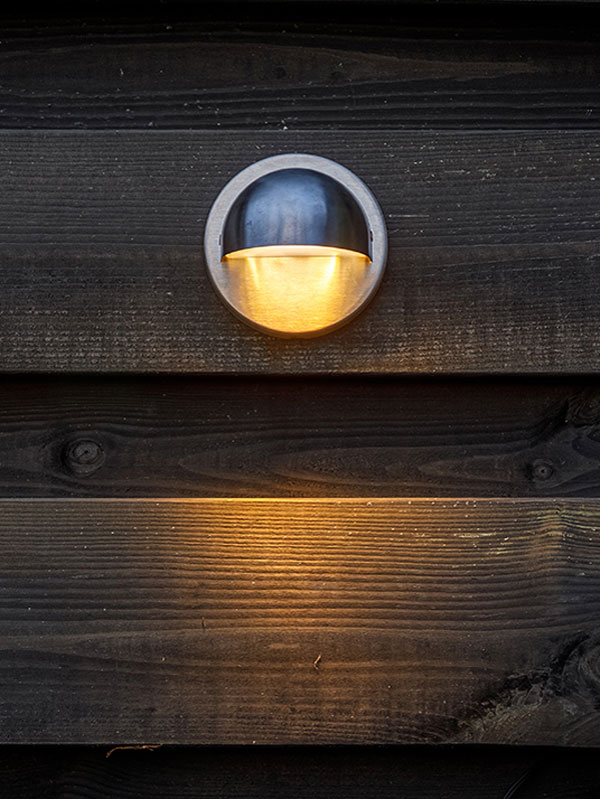 Wandleuchte Palm an Holzzaun montiert