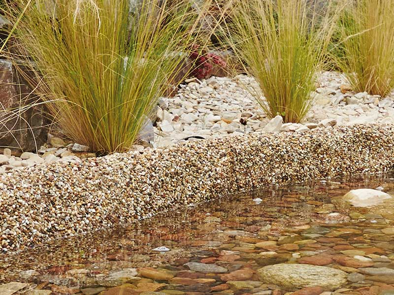 Steinfolie Sand in einem Bachlauf verbaut